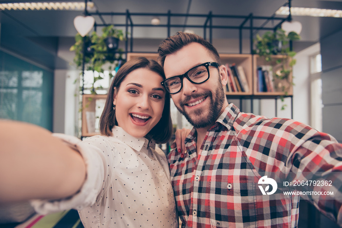 Two happy laughing colleagues making selfie during break