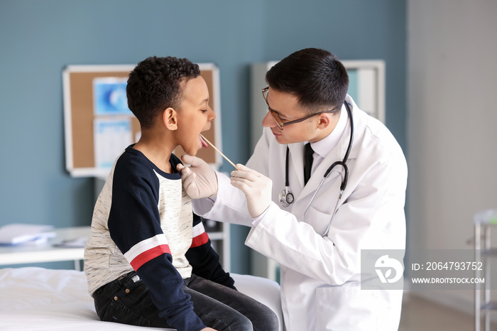 Pediatrician examining African-American boy in clinic