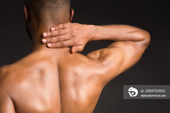 Shirtless black man suffering from pain in his neck