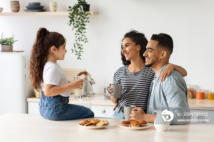 Happy arab family enjoying breakfast at cozy kitchen