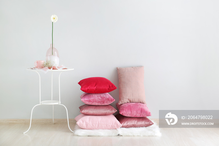 Soft pillows with table near light wall