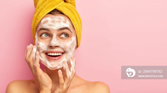 面部护理概念。快乐快乐的年轻女子用肥皂洗脸的特写，哈