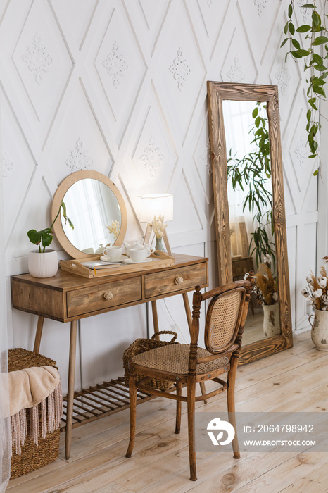 Female table for makeup in bedroom. Large mirror and wooden furniture.