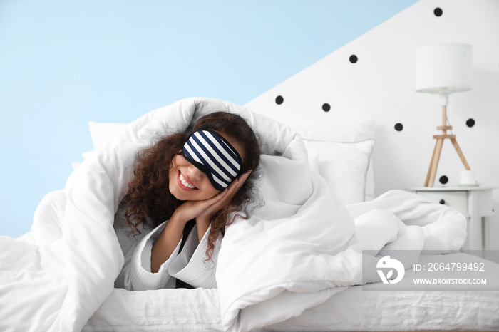 Morning of young woman with sleeping mask lying in bed