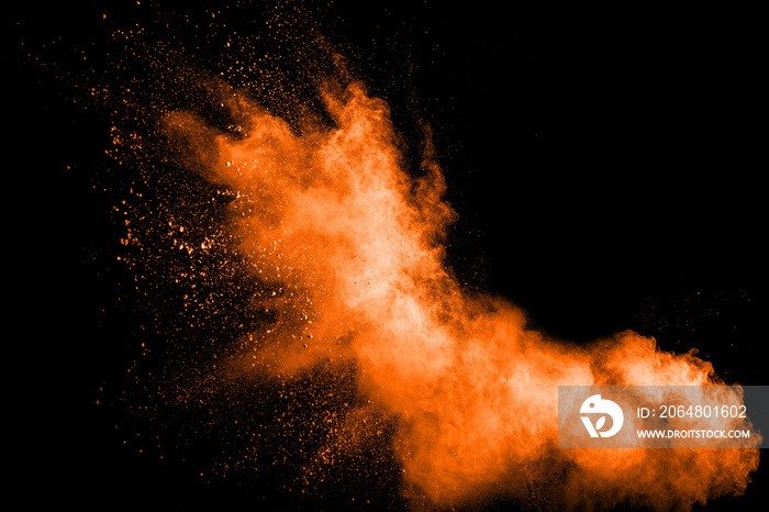 抽象橙色粉尘在黑色背景下爆炸。抽象橙色粉末飞溅在深色背景上