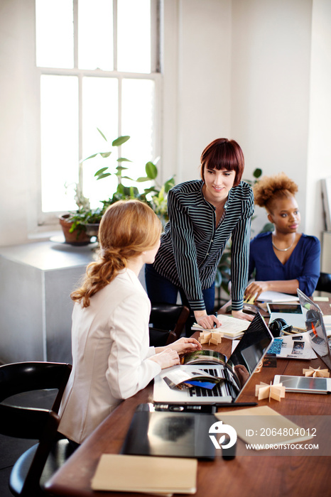 Young businesswomen discussing project in office