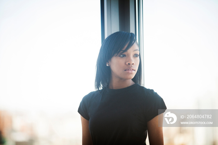 Young woman looking through window