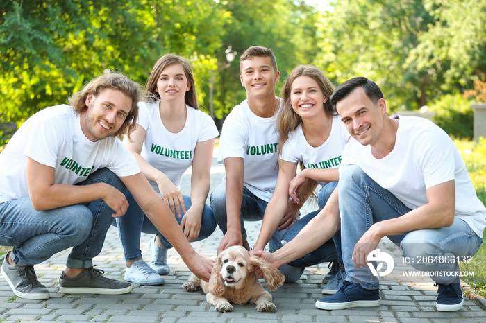 Volunteers with cute dog outdoors