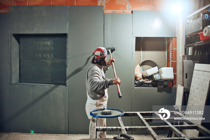 Painter painting walls with a extender roller indoors.