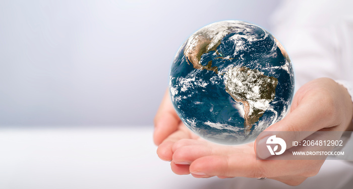 World water day. A globe in the shape of a drop of water falling onto hand woman on blue sea backgro