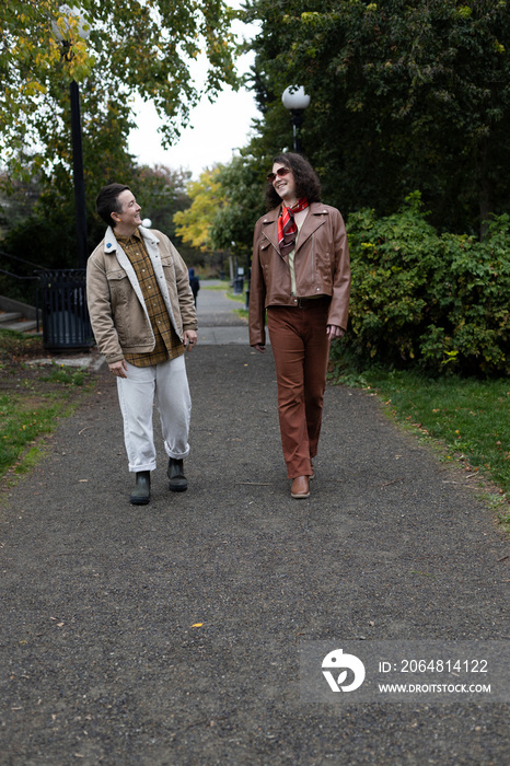 lifestyle image of transgender nonbinary friends talking and walking in the park