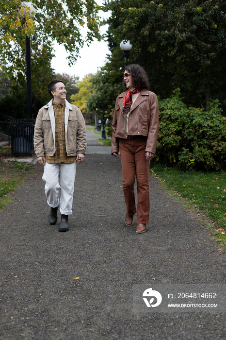 lifestyle image of transgender nonbinary friends talking and walking in the park