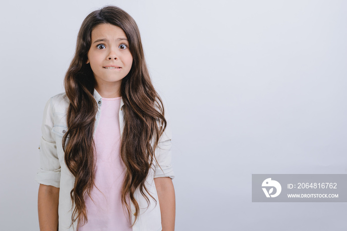 Studio portrait of scared little girl looks unhappy.- Image