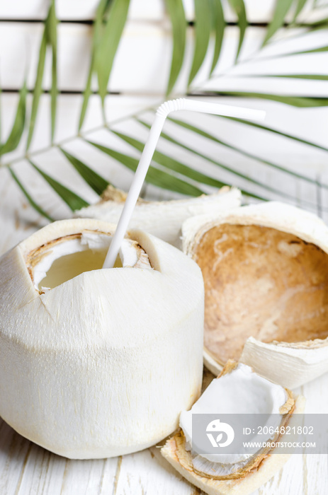 Young coconut on white wooden background.