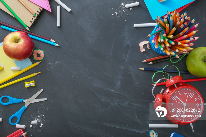 Set of school stationery on blackboard