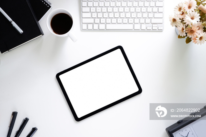 Office desk table with tablet,coffee cup ,pencil ,flower ,notepad on white desk. Top view with copy 