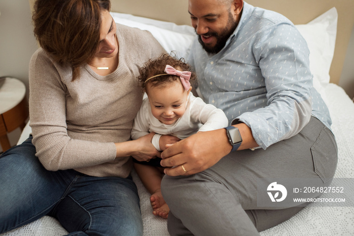 High angle view of parents with cute daughter relaxing on bed at home