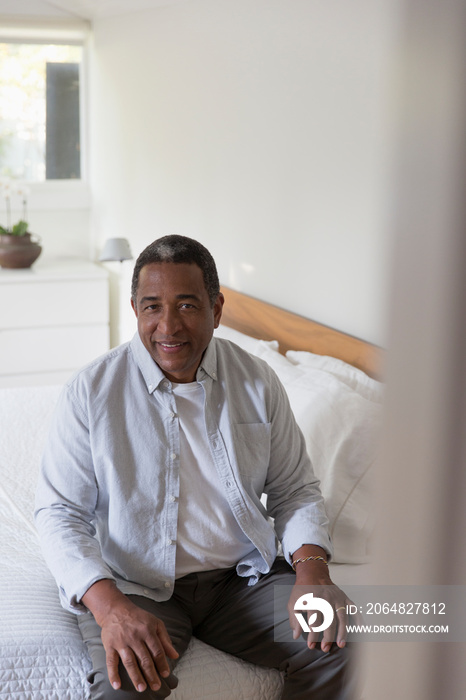 Portrait senior man sitting at edge of bed