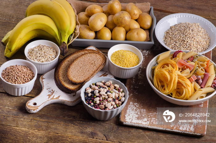 Foods high in carbohydrate on rustic wooden background.