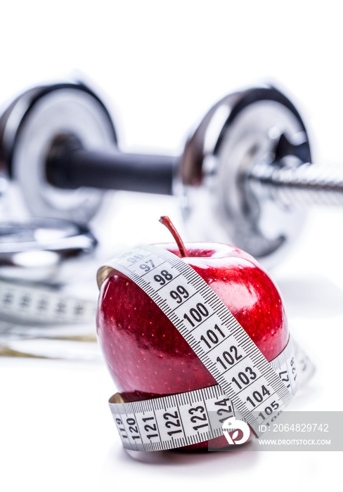 Fresh red apple, tape measure, and in the background Fitness dumbbells. Healthy lifestyle diet and e