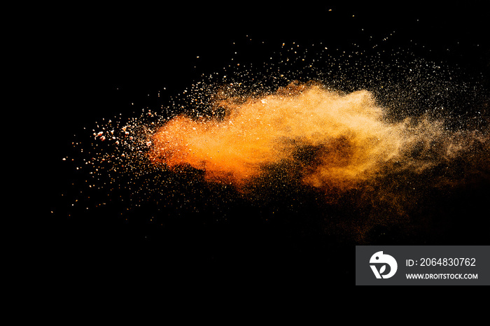 Abstract orange powder explosion isolated on black background.