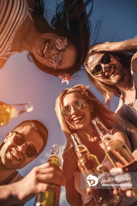 Friends drinking beer on beach