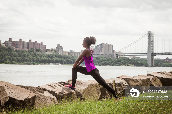 Side-view of young woman stretching