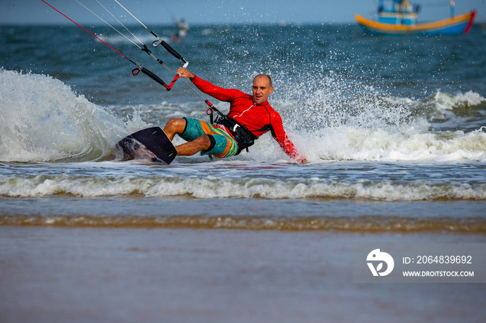 Kitesurfing on the waves of the sea in Mui Ne beach, Phan Thiet, Binh Thuan, Vietnam. Kitesurfing, K