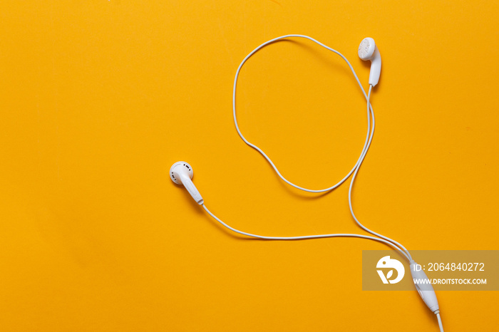 Wired headphones on yellow background