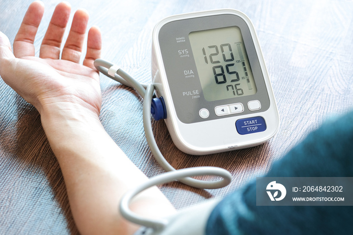 男子用数字压力表检查血压监视器和心率监视器。健康护理和