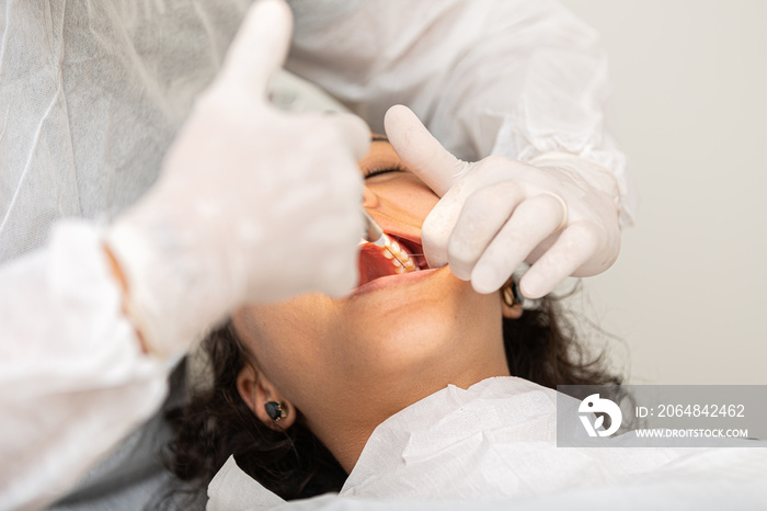 Young woman being seen in a dentists office. Concept of toothache, wisdom tooth extraction, anesthe