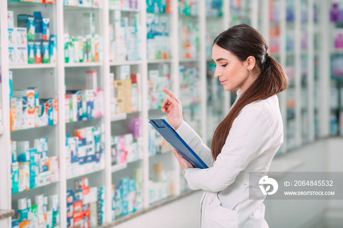 pharmacist chemist woman working in pharmacy drugstore with tablet.