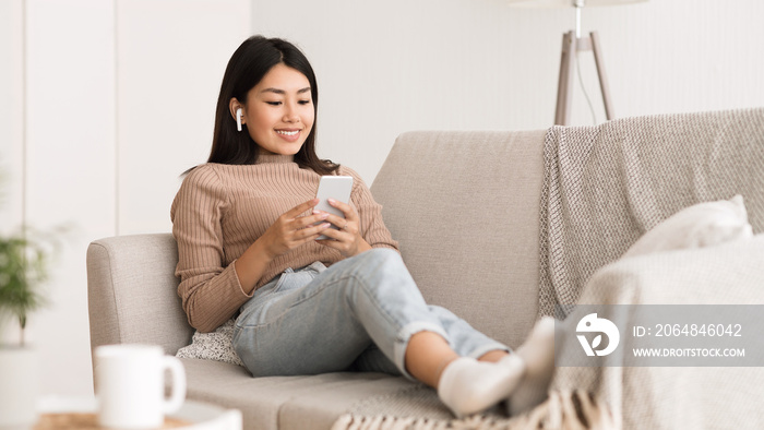 Millennial girl enjoying music online in airpods