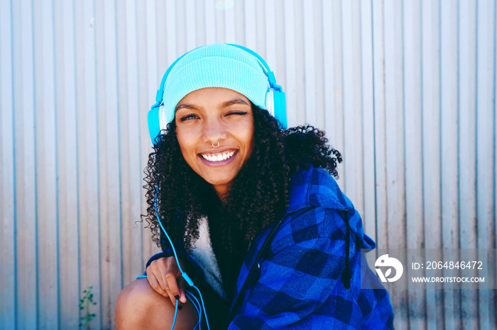 Divertida chica joven escuchando música con unos auriculares