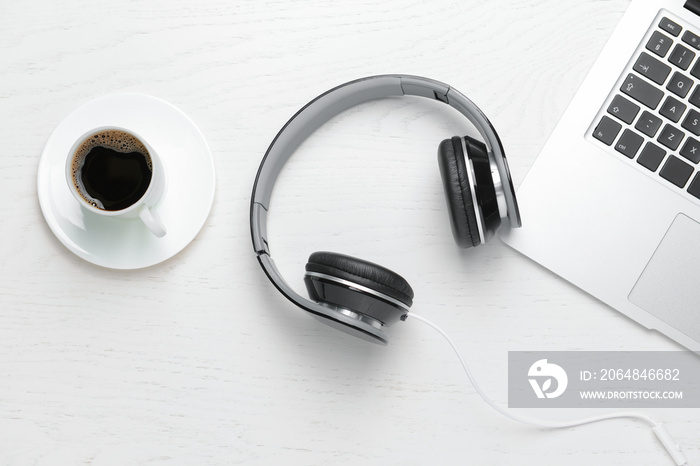 Modern headphones, laptop and cup of coffee on white background