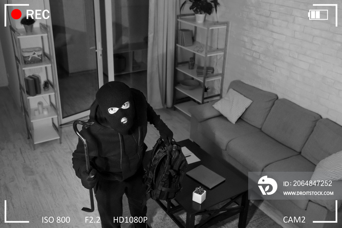 带撬棍的小偷从摄像机进入房屋