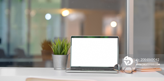 Trendy home-office with open blank screen laptop computer