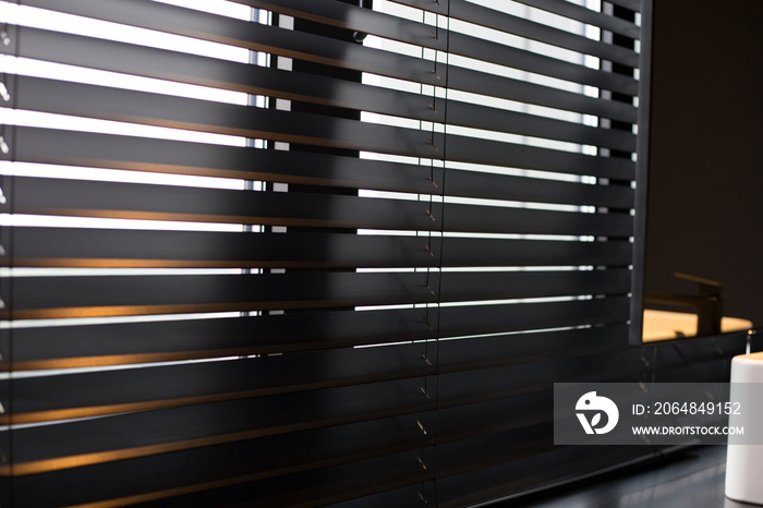 Wood blinds Coulisse black color closeup on the window. Wooden plate 50mm wide. Venetian blinds in t