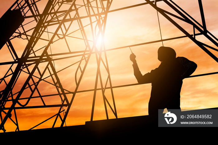 silhouette engineer holding radio and ordering at construction working site