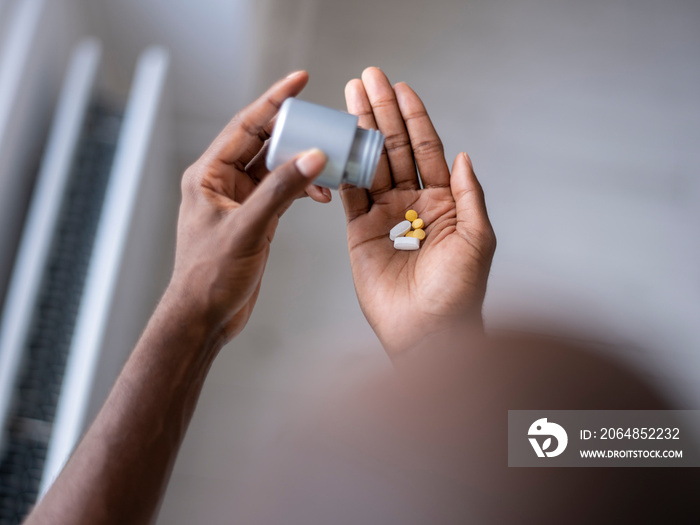 Close-up of person pouring pills on hand