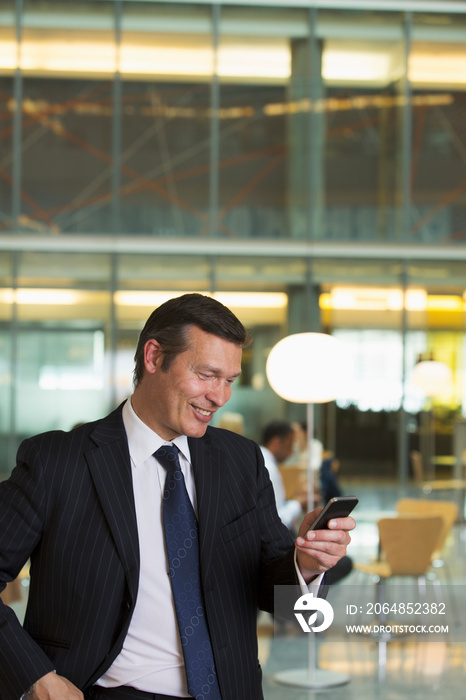 Corporate businessman using smart phone in office