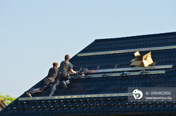 Installing modern black solar panels on the roof