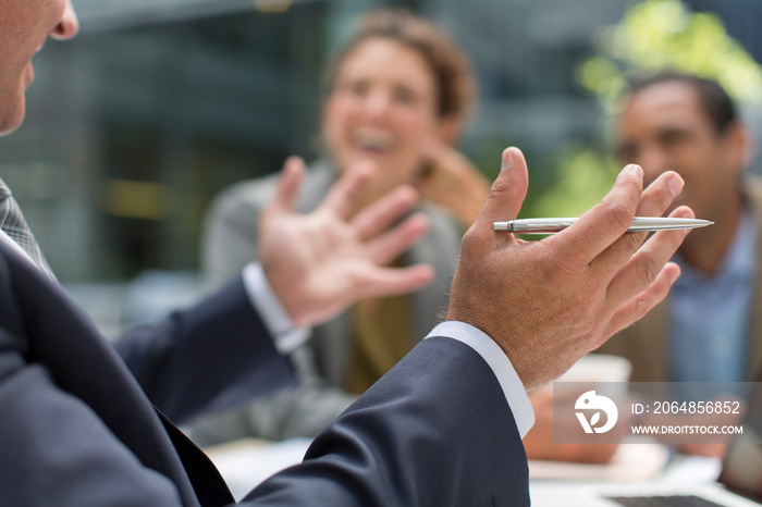 Businessman gesturing in meeting with colleagues