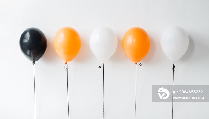 节日、装饰和派对概念-万圣节或出生时的橙色、黑色和白色气球