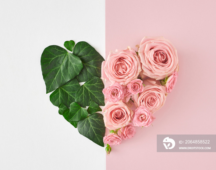 白色和淡粉色背景上的绿色叶子和粉色花朵形成的心形。简约自然l