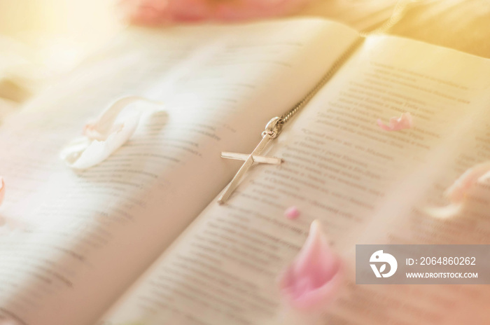 Cross with Bible. Closeup of christian cross and bible with flowers