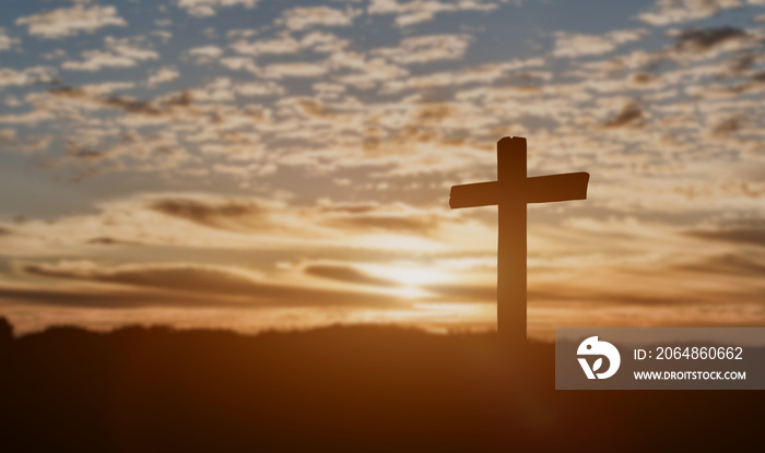 Silhouette of catholic cross at sunset background.