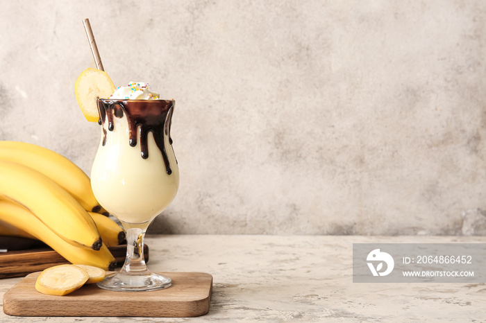 Glass of tasty banana milkshake on grunge background