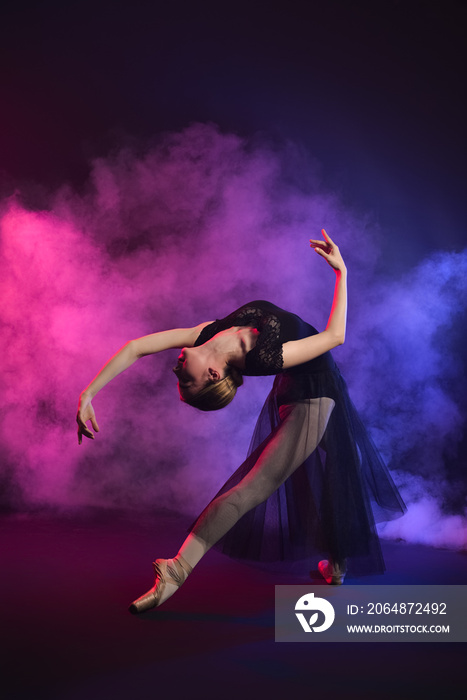 Beautiful young ballerina on dark color background