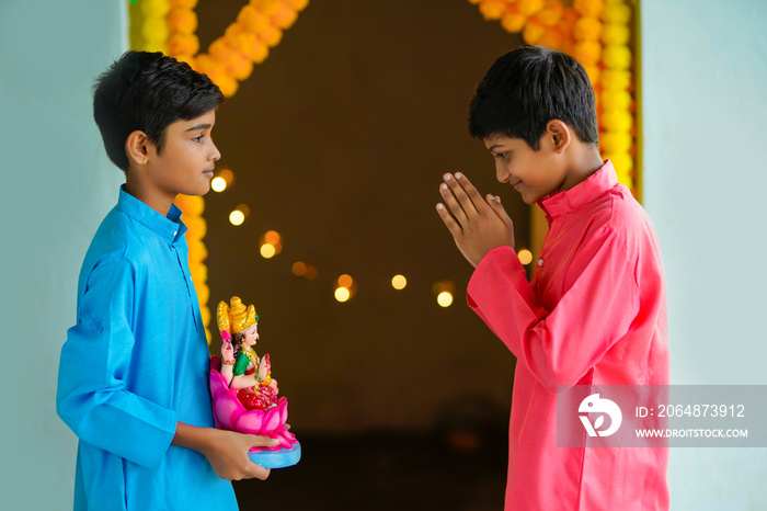 可爱的印度小男孩手捧着女神laxmi sclupture，庆祝排灯节。